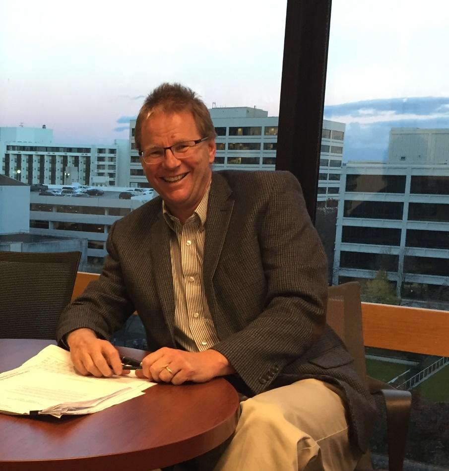 Kevin Reynolds seated at a desk, smiling.